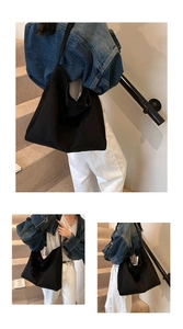Detail view of large black suede tote bag showing soft texture and spacious interior