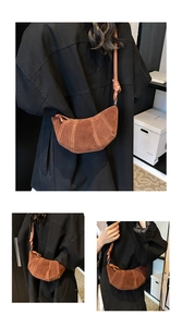 Dettaglio di una borsa croissant in camoscio marrone con trama a pieghe e nodo sulla tracolla