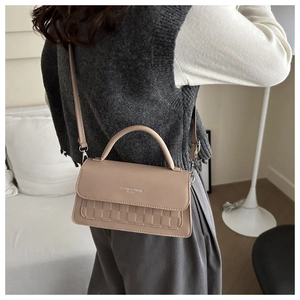 Detail of beige crossbody bag with checkered texture and Fashion Trend lettering