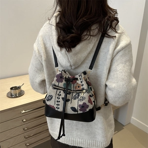 Bolso bombonera vintage tejido floral con ribetes de cuero negro y cordón de ajuste