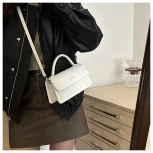 Detail of white vintage crossbody bag with FASHION TREND lettering and adjustable strap