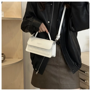 Detail of white square crossbody bag with embossed pattern and fashion trend text