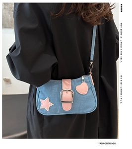 Dettaglio borsa a tracolla in denim azzurro con stelle e cuori in pelle rosa