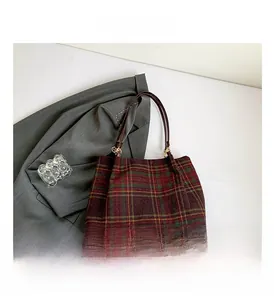 Close-up of British plaid wool tote bag with golden metal hardware and soft texture
