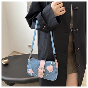 Dettaglio della borsa a spalla in denim con cuori in pelle rosa e catena metallica