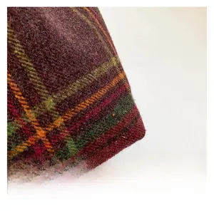 Close-up of the vintage red plaid wool fabric with thick texture and colorful stripes