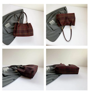 Detail view of red and green plaid handbag with leather straps and gold chain hardware