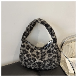 Detail of plush leopard print handbag with silver zipper closure and soft faux fur texture