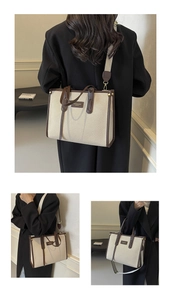 Detail view of large canvas tote bag with brown leather trim and wide shoulder strap