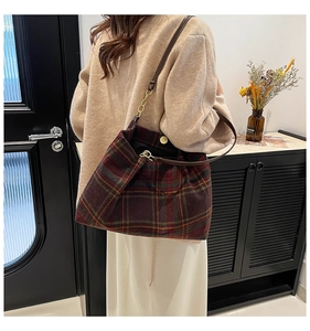 Detail of vintage plaid tote bag with leather chain strap shown on a shoulder