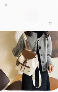 Détail d'un sac à dos tissé beige avec rabat marron, fermoir doré et pendentif