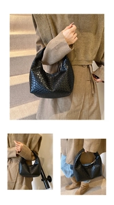 Detailed close-up showing textured woven leather craftsmanship of black hobo shoulder bag