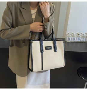 Detail of canvas and black leather tote bag with FASHION & BAGS logo engraving