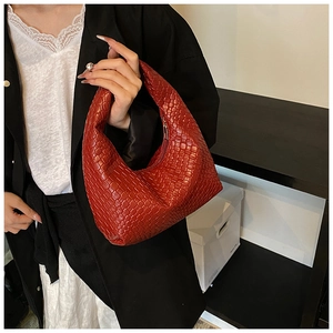Detail of red woven leather hobo bag showing intricate texture and metallic zipper