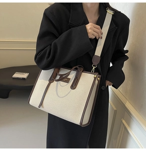 Detail of canvas tote with brown leather handles and premium embossed leather patch