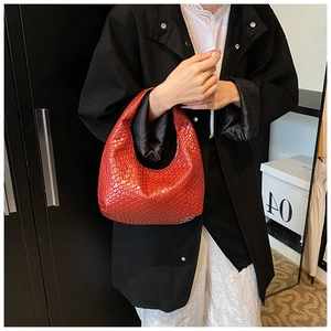 Detailed view of dark red hand-woven leather texture on a stylish hobo shoulder bag