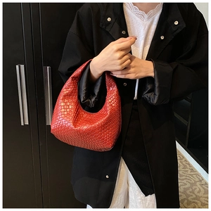 Close-up of red woven leather texture on a stylish French hobo crescent handbag