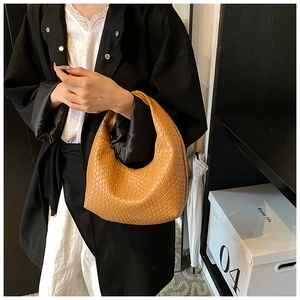 Detail of camel woven hobo shoulder bag showing premium leather texture and minimal design