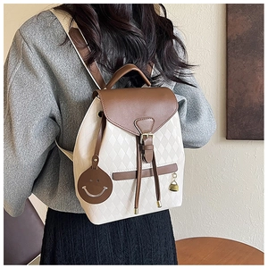 Close-up of quilted drawstring bucket bag featuring a cream and brown color-block design