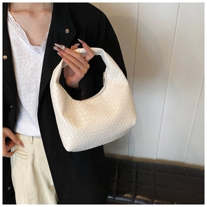 Detailed view of a white woven faux leather hobo bag with a gold zipper closure