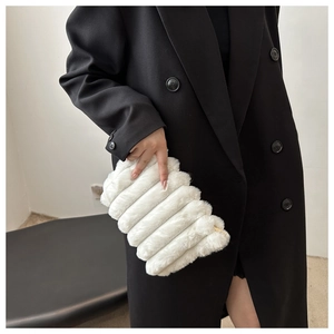 Détail du sac à main en fausse fourrure blanche avec texture rayée et zip métallique