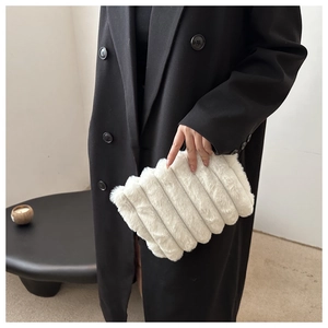 Détail d'une pochette en fausse fourrure blanche avec texture pelucheuse et motif ondulé