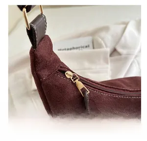 Détail du sac fourre-tout bordeaux en daim avec zip doré et coutures de haute qualité