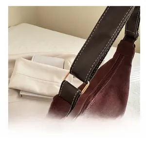 Gros plan d'un anneau doré reliant la bandoulière en cuir marron au sac fourre-tout vintage