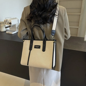 Minimalist canvas and leather tote bag shown on model in a stylish cafe setting