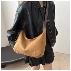 Retro large brown suede tote bag with wide strap worn by a model in casual style