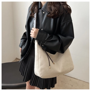 Détail du sac hobo crème en texture suédine avec cordon marron et ornements dorés