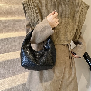 French style black woven leather hobo handbag for women, shown on shoulder in natural light