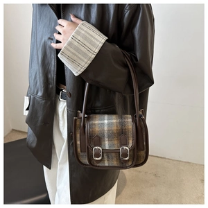 Dettaglio del motivo a quadri retrò e tracolla in pelle di una borsa a tracolla chic