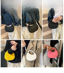 Detail view of crescent moon handbags in multiple colors with embossed crocodile pattern