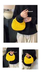 Detail of bright yellow dumpling bag with crocodile pattern and crescent design