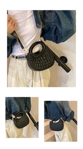 Close-up of black quilted PU leather handbag with gold hardware and round handle
