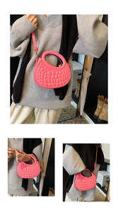 Detail showing pink dumpling bag with crocodile pattern and round handle for women