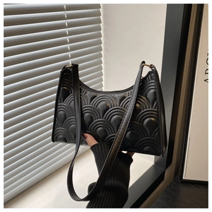 Detail of black quilted wave pattern texture on a retro minimalist crescent underarm bag