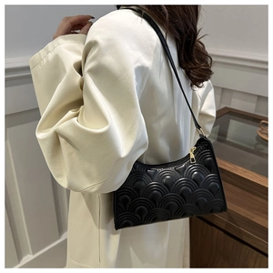 Detail of black crescent shoulder bag featuring textured PU leather and gold hardware