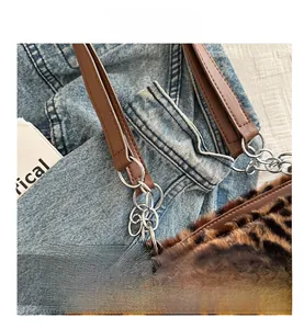 Détail du sac cabas en peluche léopard avec bandoulière en cuir et chaîne en métal