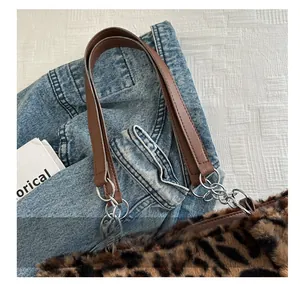 Détail d'un sac cabas en fausse fourrure léopard avec anse en cuir et maillons argent