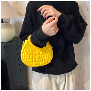 Detail of bright yellow crescent handbag featuring croc-embossed texture and gold ring
