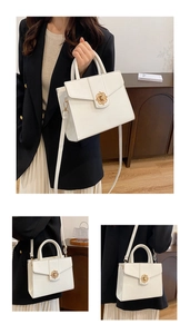 Detail of white structured PU leather handbag with golden petal twist lock and top handle