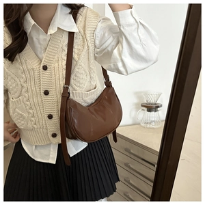 Sac hobo marron rétro en forme de croissant porté avec une tenue de style vintage