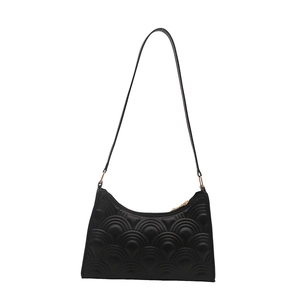 Minimalist black shoulder bag featuring textured semi-circular embossing and gold metal buckles