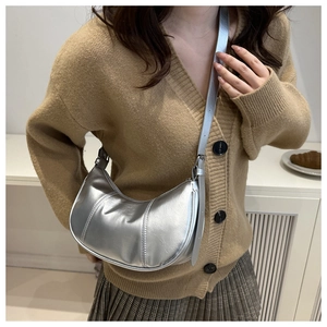 Sac hobo argenté en forme de croissant porté avec une tenue d'automne chic