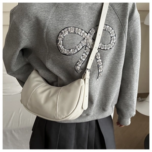 Sac bandoulière demi-lune blanc crème avec bandoulière réglable porté à l'épaule