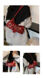 Detailed views of red glossy pleated underarm bag with large silver buckle and punk style
