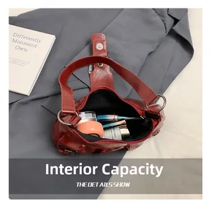 Detailed internal view of deep red crescent bag showing storage for makeup essentials