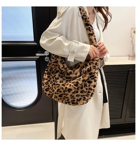 Detail of plush leopard print tote bag styled with a white trench coat in a modern setting